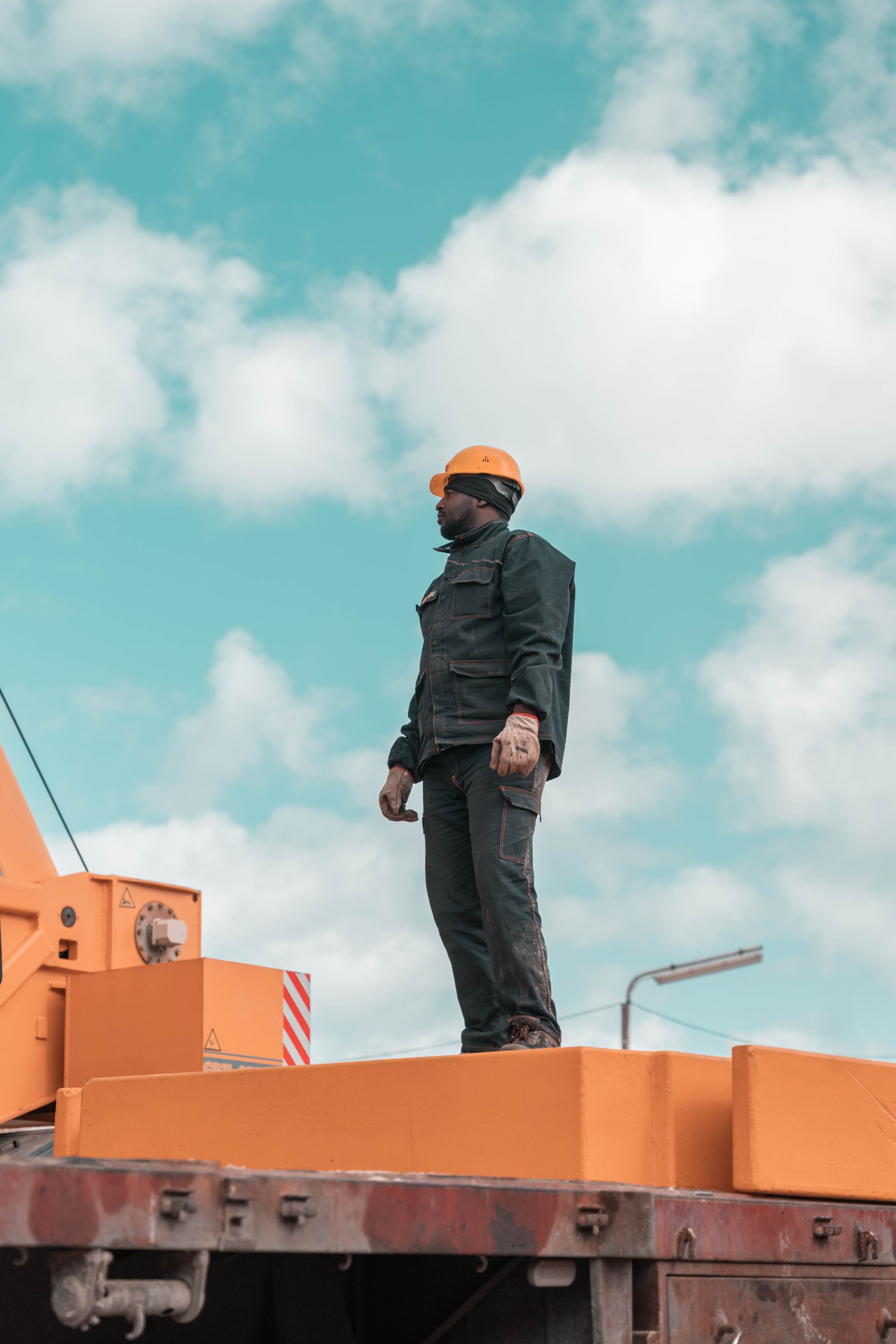 Construction worker on a crane against a blue sky