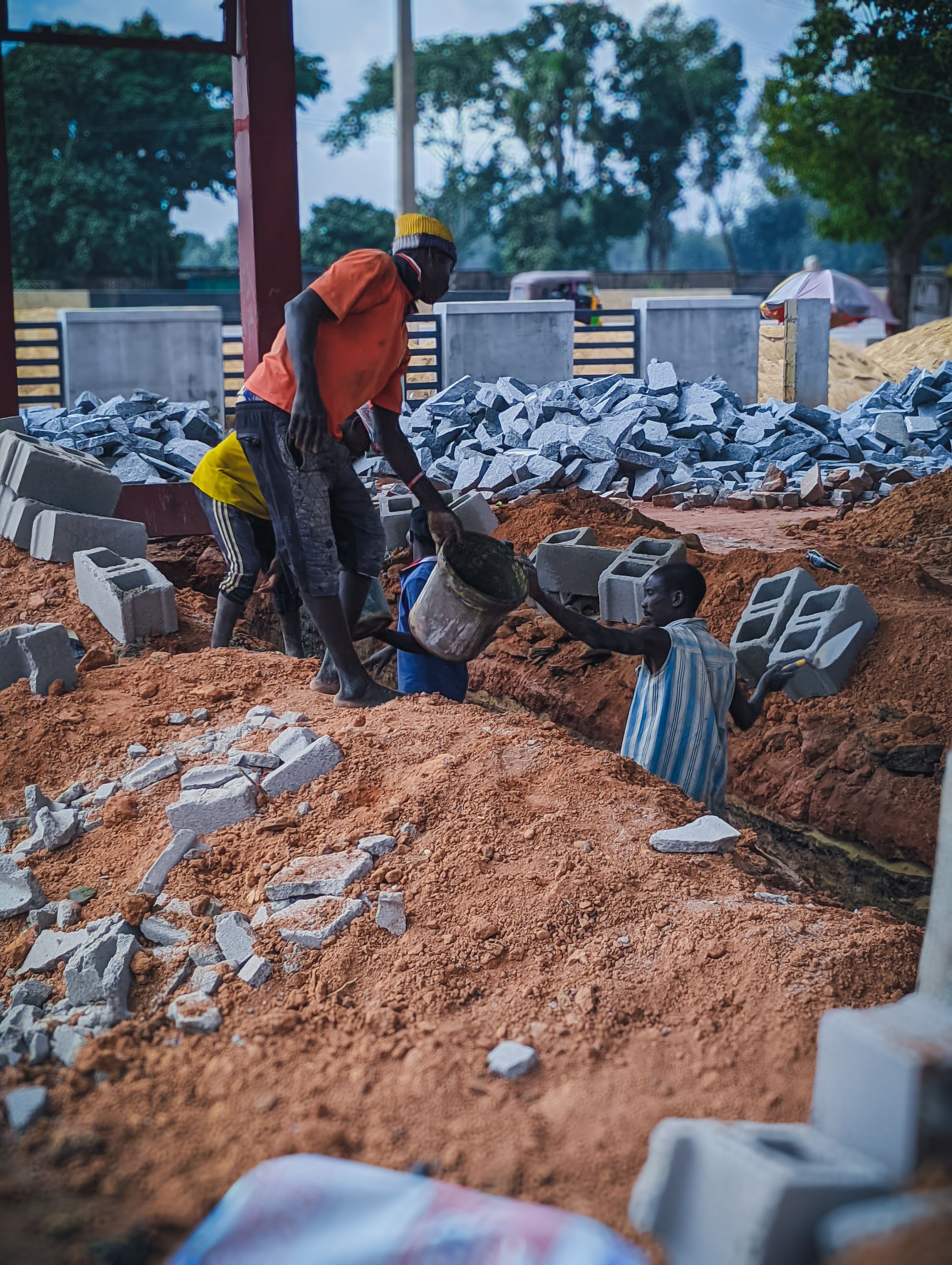 Workers handling bricks on a site in Kaduna, Nigeria